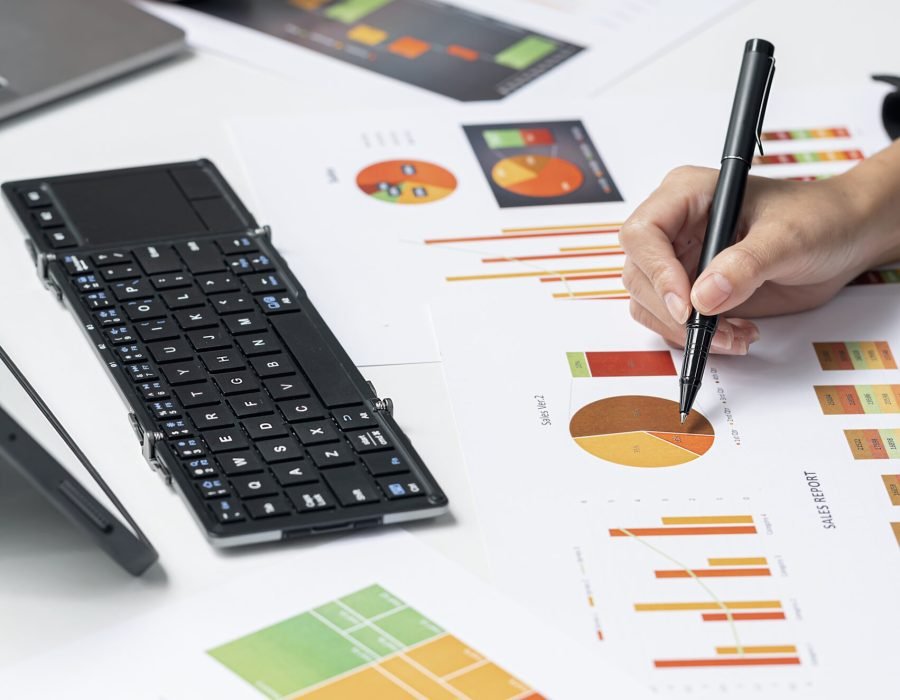 Cropped shot of business people hands working on graph and chart of business data information at office desk. Vertical view.