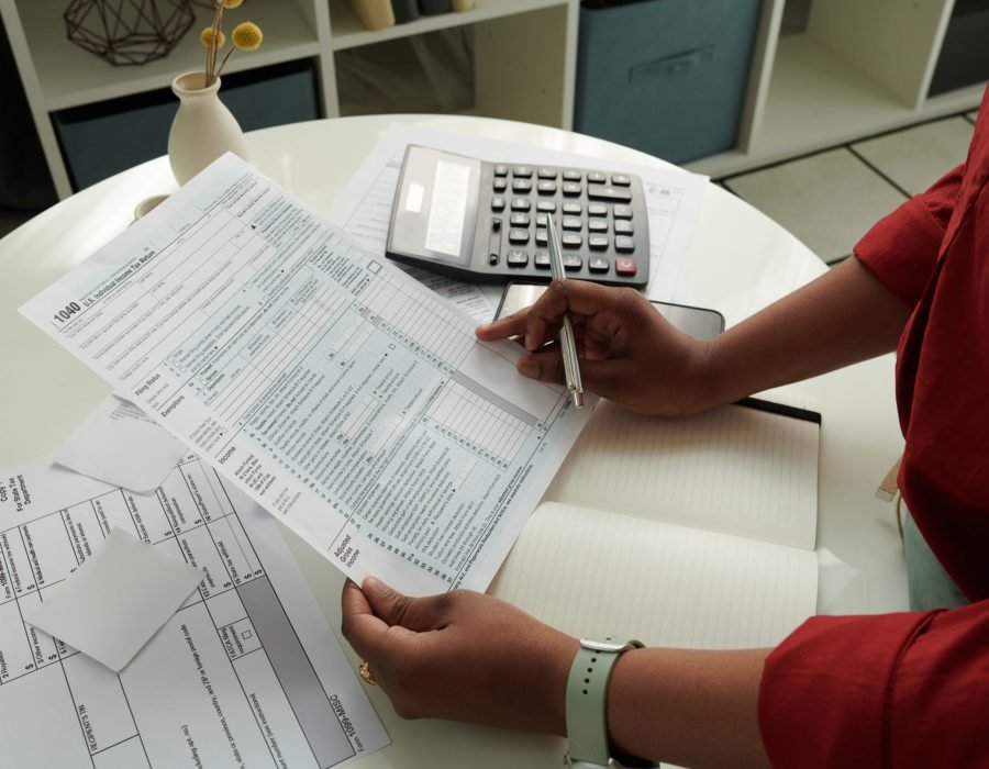 Close-up of African girl checking and calculating her domestic bills at table using calculator
