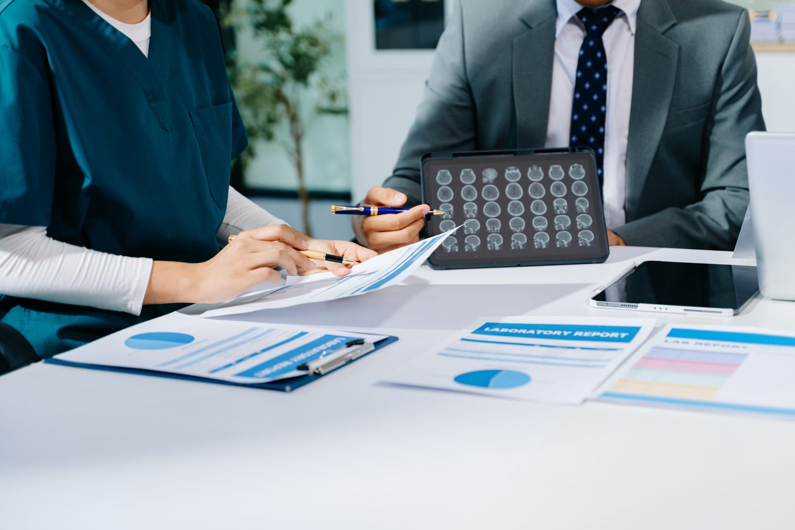 Doctors and consultant discussing brain scan and lab reports in Doctors and consultant discussing brain scan and lab reports in a modern clinic. Healthtech, diagnostics, teamwork, and patient care concept