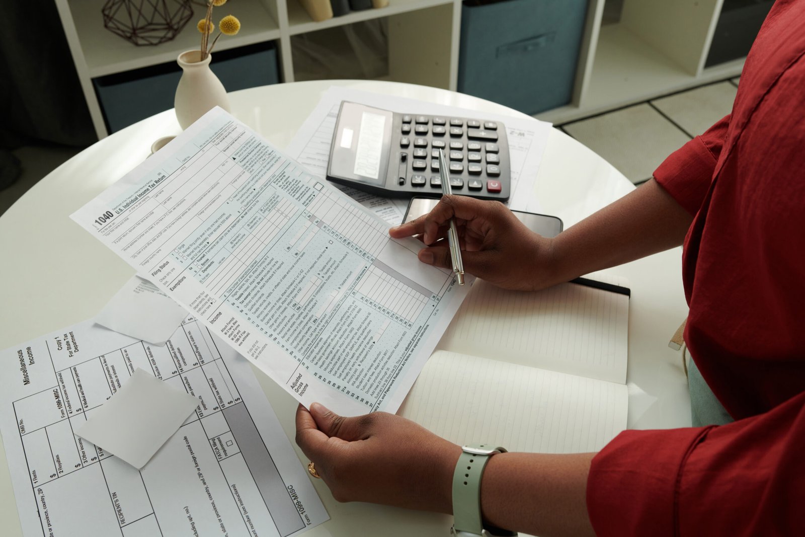 Woman calculating her domestic bills Close-up of African girl checking and calculating her domestic bills at table using calculator